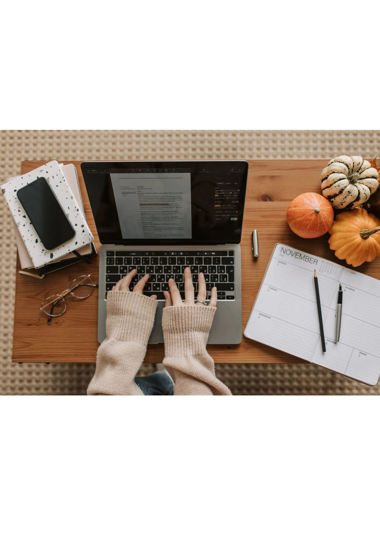 Laptop, planner, and coffee on a cozy desk